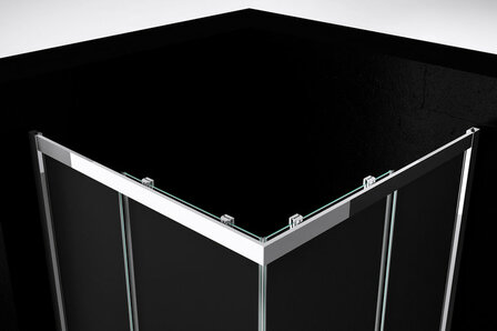 Hoek van een moderne douchecabine met glanzend chroom en zwarte glazen panelen, strak gecombineerd in een minimalistische stijl.