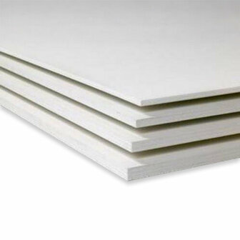 Stapels witte, vlakke platen met een glanzende afwerking liggen op elkaar, zichtbaar in een lichte omgeving.