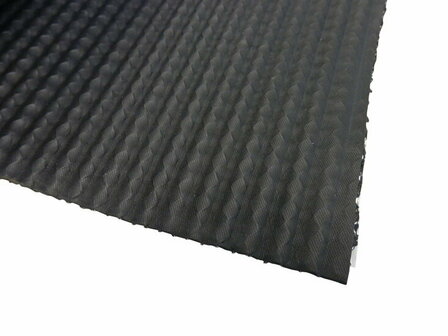 Zwarte, geribbelde mat van rubberachtig materiaal met een lichte glans en een gestructureerd oppervlak.