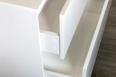 Witte lade met een glanzende afwerking, gedeeltelijk geopend, op een houten vloer.