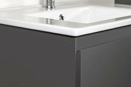 Grijze keukenkast met een glanzend wit aanrechtblad en een metallic rand, strak en modern van design.