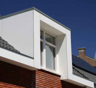 Moderne woning met een wit afgewerkte gevel en een dak van grijze dakpannen, onder een heldere blauwe lucht.