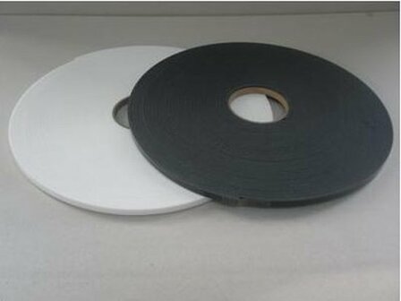 Zwarte en witte rollen tape liggen plat op een lichte achtergrond, met een opening in het midden.