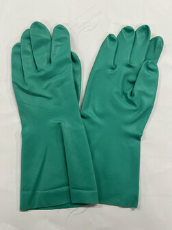 Groene rubberen schoonmaakhandschoenen liggen plat op een witte ondergrond met textuur.