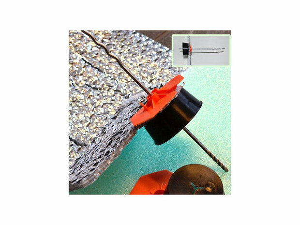 Zwart plastic onderdeel met oranje ring, bevestigd aan een metalen draad, ligt op een lichtblauwe ondergrond met een zilverachtige textuur.