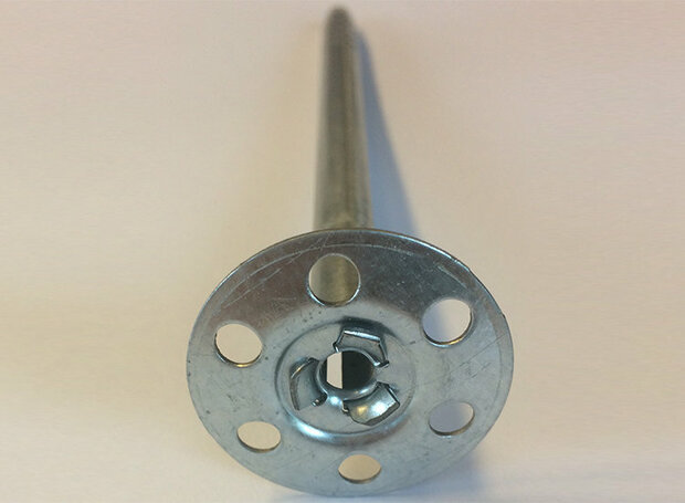 Zilveren metalen schroef met een ronde voet en gaten, gericht naar de camera op een lichte achtergrond.