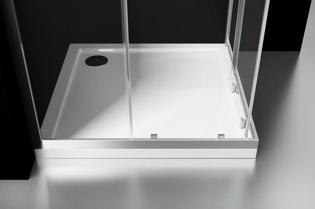 Een moderne douchebak in wit acryl met glaswanden en een chroomkleurige afvoer, geplaatst op een strak zwart keramisch oppervlak.