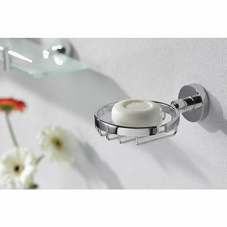 Ronde zeepdispenser van chroom met een witte, ronde zeep en een strakke, moderne muurbevestiging.