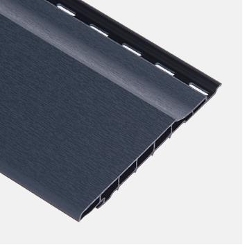 Grijze, glanzende dakpan met een gestructureerd oppervlak en een zwarte rand langs de onderkant.