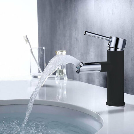 Zwarte mengkraan met chroomaccenten, glanzend water dat uit de tuit stroomt, modern en stijlvol op een witte wastafel.