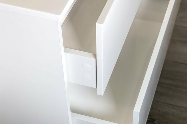 Witte lade met een glanzende afwerking, gedeeltelijk geopend, op een houten vloer.