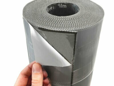 Zwarte zelfklevende folie op een rol met een hand die een gedeelte van de beschermlaag verwijdert.