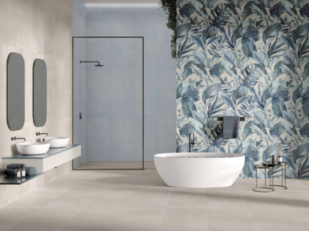 Moderne badkamer met een ronde, witte badkuip, groene plantenwand en strakke, grijze tegels. Minimalistische inrichting met stijl.